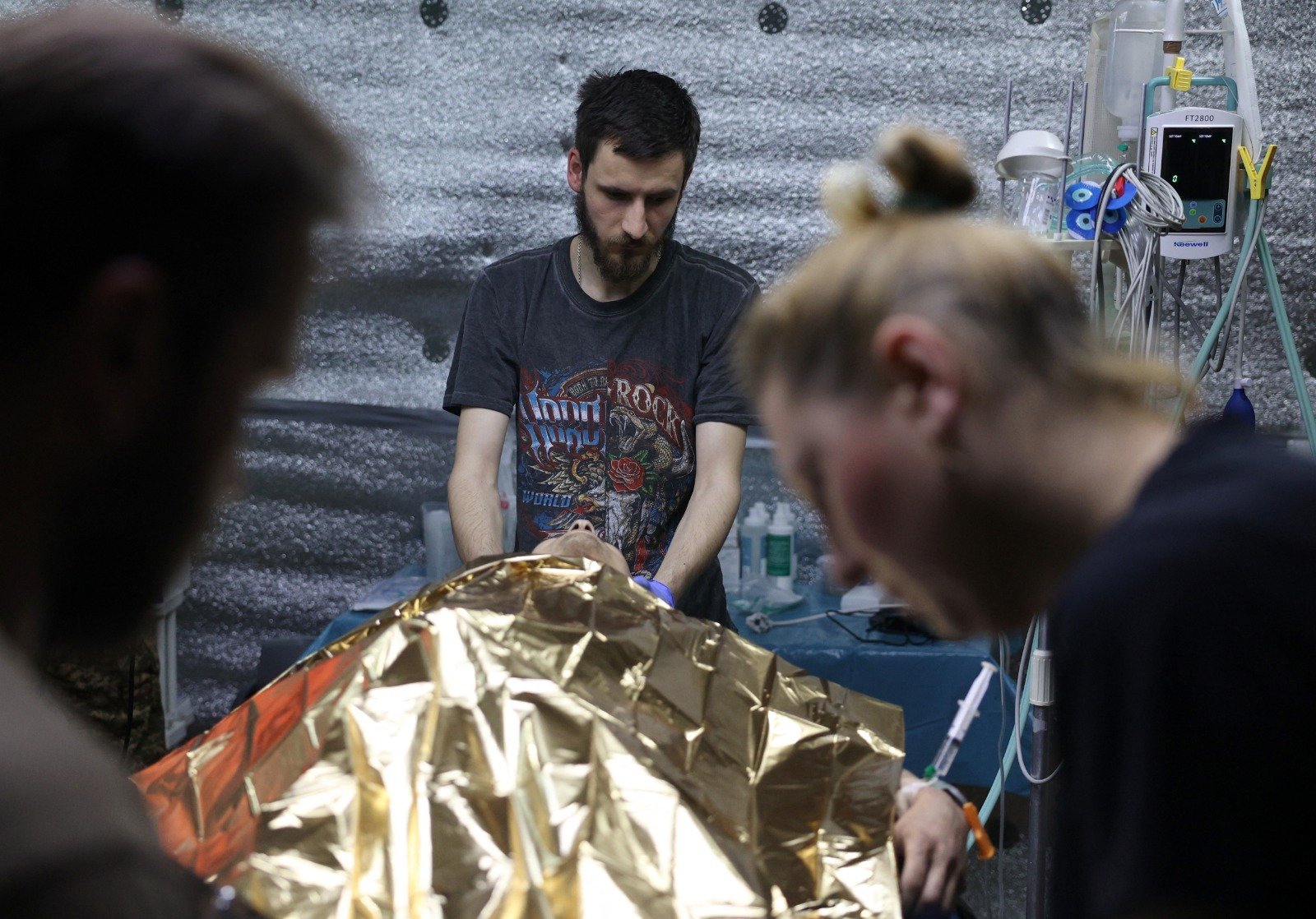 乌克兰国民警卫队第12“亚速”旅的乌克兰军医本月16日，在顿涅茨克地区为一名受伤士兵提供医疗援助。（图取自法新社）