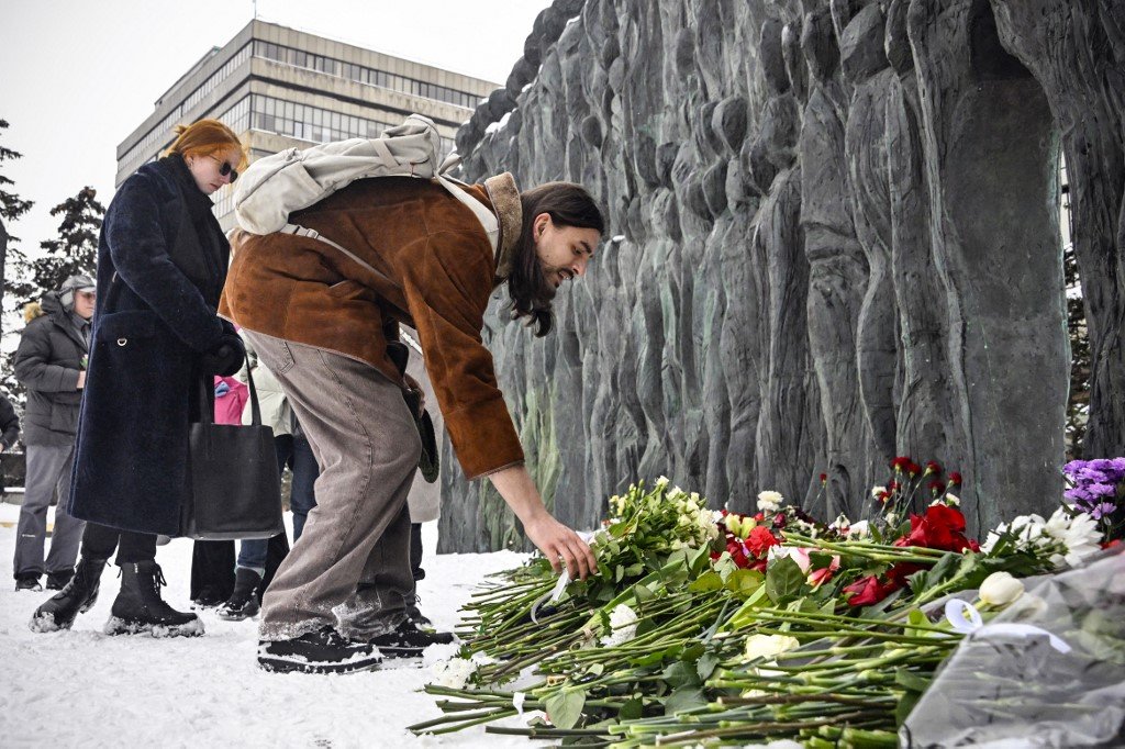 周六在莫斯科，人们前往政治镇压受害者的纪念碑“悲伤之墙”向纳瓦尔尼献花。（图取自法新社）